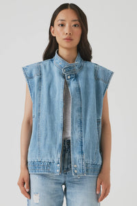 Woman wearing a light blue denim vest over a gray shirt on a white background